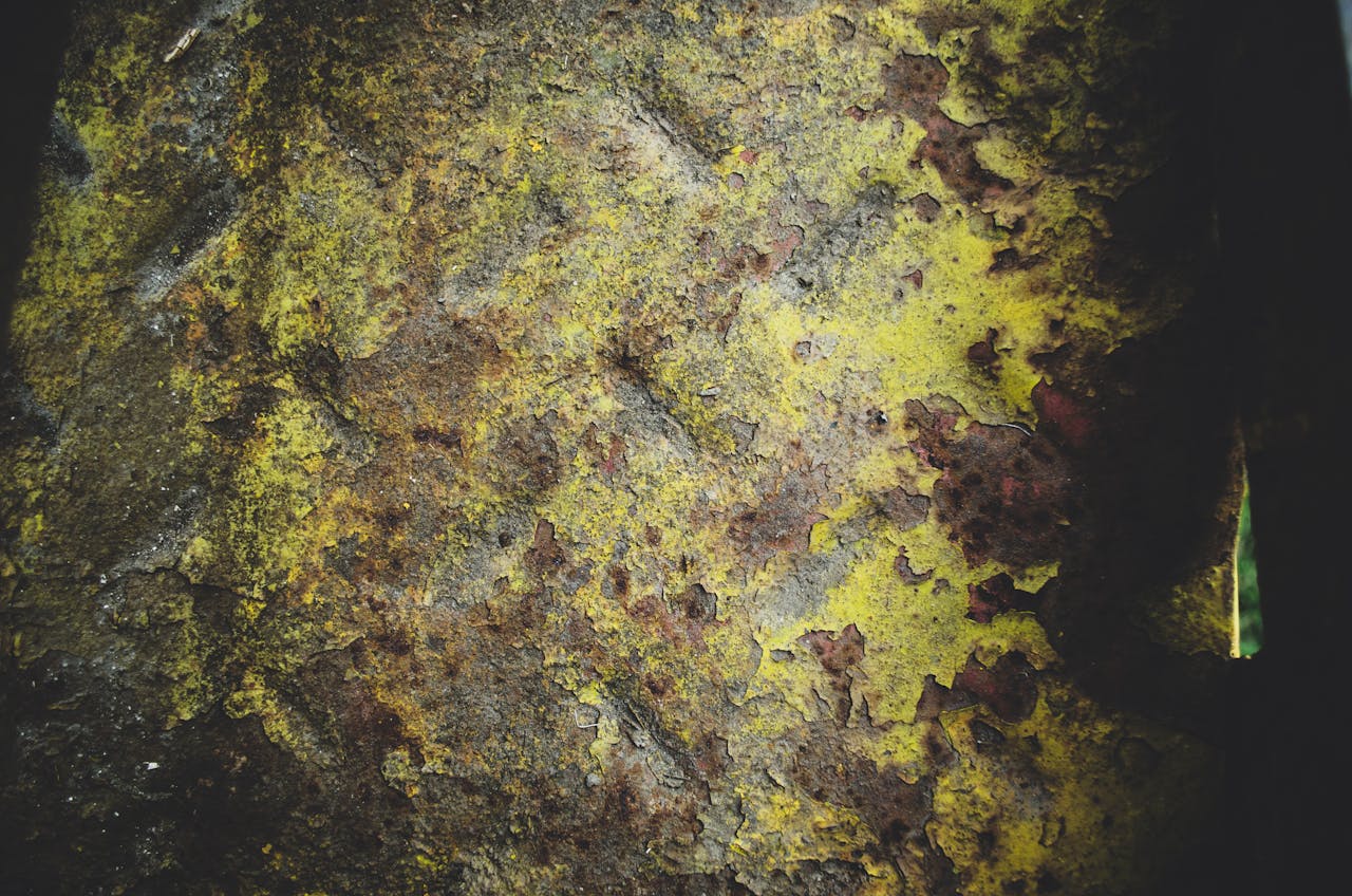 Close-up of a grungy wall with vivid textures and a mix of yellow and brown colors.